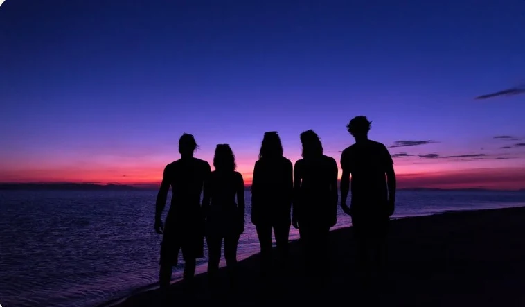 Friends watching the sunset from an island beach
